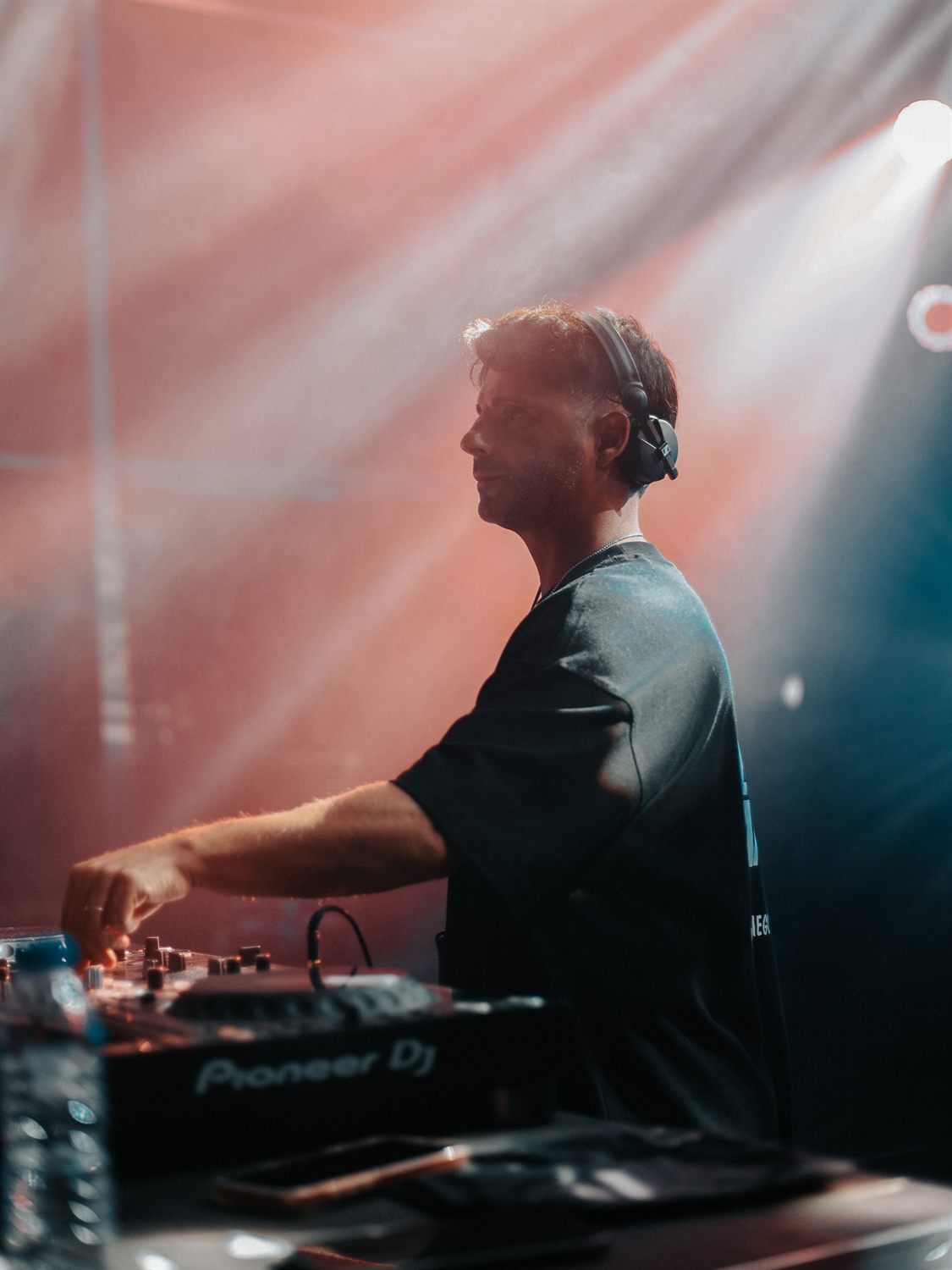 DJ Diego Morales de perfil, com auscultadores, em palco